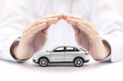Foto: Hände über kleinem Auto